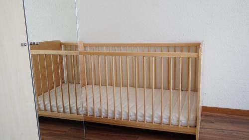 a crib in a room with a glass door at Ufem Egg Ferienwohnungen in Innertkirchen