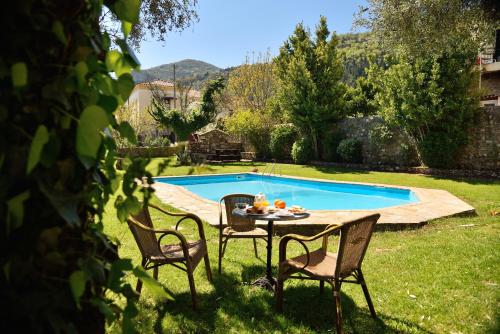 a table and chairs in front of a swimming pool at Byzantion Hotel in Mystras