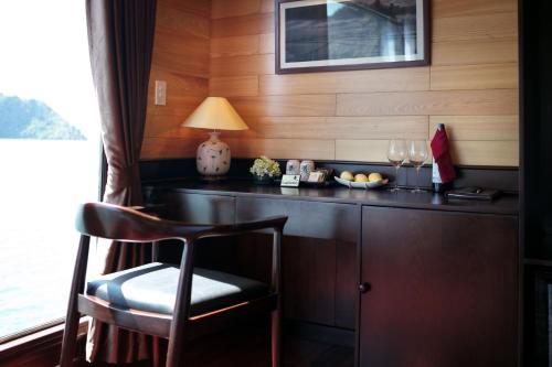 a room with a desk with a chair and a lamp at V'Spirit Cruise in Ha Long