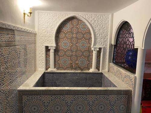 a room with a wall with a window and a table at APPARTEMENTS NIA CONFORT, Plein centre ville, avec TERRASSE in Fès