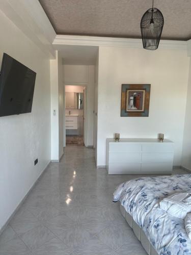 a bedroom with a bed and a flat screen tv at APPARTEMENTS NIA CONFORT, Plein centre ville, avec TERRASSE in Fès