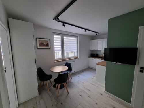 een keuken met een tafel en stoelen in een kamer bij Apartamenty Katowice Chopina 16 in Katowice