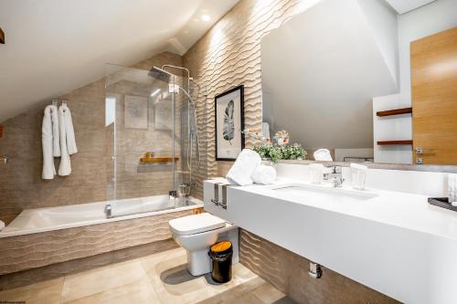 a bathroom with a sink and a toilet and a tub at ON Village in Matalascañas
