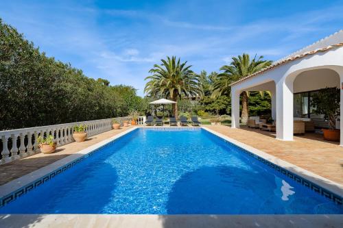 a swimming pool in a backyard with a house at Casa Luzerna in Carvoeiro