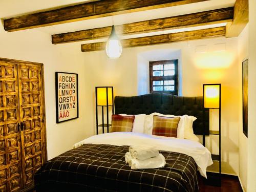 a bedroom with a bed with a black and white blanket at Masia Mimosa in Darnius