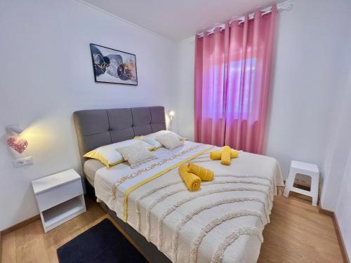 een slaapkamer met een bed met twee gele kussens erop bij Apartmani Marijana & Iva in Jadranovo
