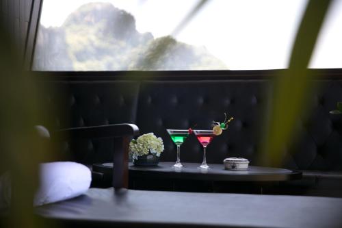 a table with two glasses on it next to a window at V'Spirit Cruise in Ha Long