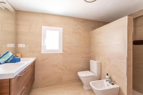 uma casa de banho com um WC, um lavatório e uma janela em CASA VISTAS AXARQUIA em Vélez-Málaga