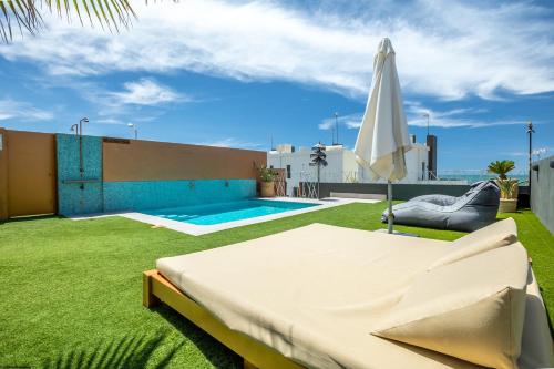 a backyard with a bed and an umbrella and a pool at ON Village in Matalascañas