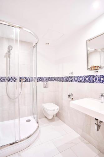 a bathroom with a shower and a toilet and a sink at Hotel Memories Budapest in Budapest
