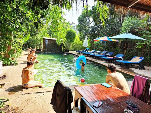 a group of people playing in a swimming pool at Nary Apartment in Siem Reap