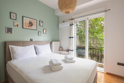 - une chambre avec un grand lit blanc et des serviettes dans l'établissement Confy Living Apartment Metaxourghio Metro Station, à Athènes