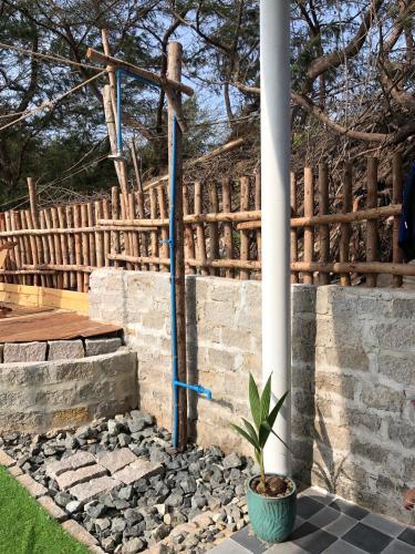 a stone retaining wall with a pillar and a potted plant at Lagi Retreat homestay Home ngay mặt biển Lagi in La Gi