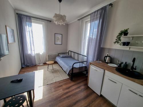 ein Zimmer mit einem Bett und eine Küche mit einem Tisch in der Unterkunft Cozy Apartment in Sofia Center in Sofia