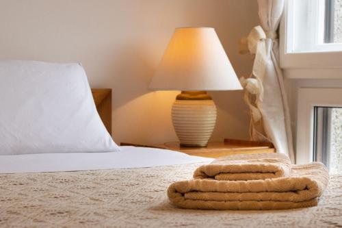 um quarto com uma cama com uma almofada e um candeeiro em B&B I FILOKSENIA em Trieste