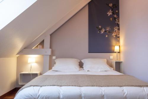 um quarto com uma cama grande e 2 almofadas em L'Abri du Bon Vent em Cancale