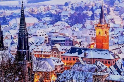 a city covered in snow with a church at L'Appar'T - Centre historique de Obernai in Obernai