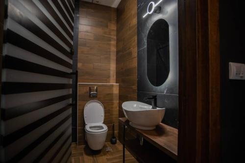 ein Badezimmer mit einem WC, einem Waschbecken und einem Spiegel in der Unterkunft Suite Music in Batajnica
