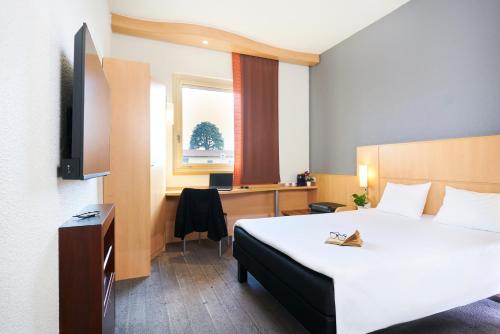 格蘭達泰的住宿－科莫宜必思酒店，配有一张床和一张书桌的酒店客房