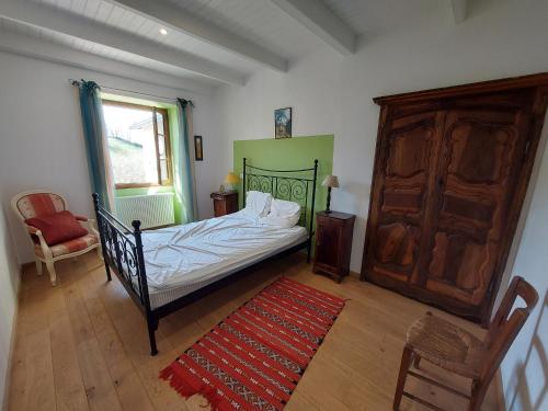 - une chambre avec un lit, une chaise et un tapis rouge dans l'établissement Gite Le Piboul, à Espinas