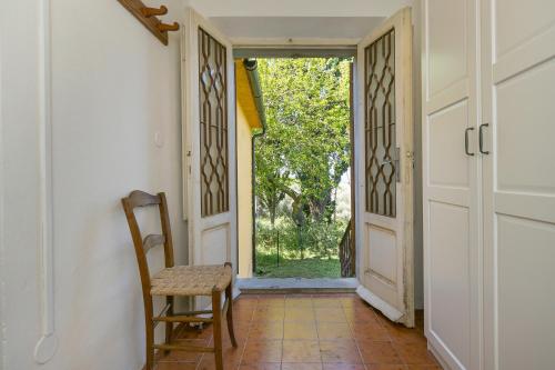 pasillo con silla y puerta abierta en Nell'antica dimora en Casciana Terme