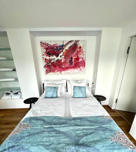 a bedroom with a large white bed with blue pillows at Lakeview Studio in St. Wolfgang