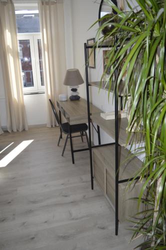 a room with a desk and a chair and a table at Agréable duplex proche de toutes commodités in Ans