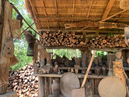 a building with a pile of wood and a bunch of logs at Khu Du Lịch Sinh Thái, Nghỉ dưỡng Homestay Hoàng Ánh - Kon Xom Luh in Kon Tum