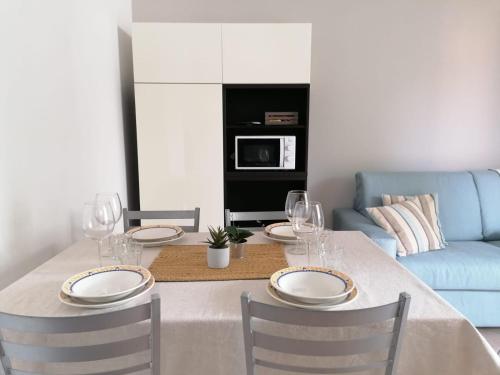 een eettafel met borden en wijnglazen bij Casa Martin: appartamento piano terra in Peschiera del Garda