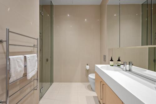 a bathroom with a sink and a toilet and a shower at Exclusive Stays - Prima Penthouse in Melbourne