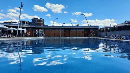 una piscina de agua azul frente a un edificio en Chalet en Las Margas Golf Club de Latas WOWRURAL, en Sabiñánigo