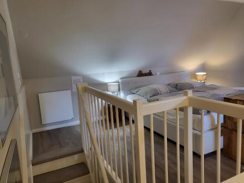 ein Schlafzimmer mit einem weißen Bett und einer Treppe in der Unterkunft Ferienwohnung 9 in der Waldstraße 23 in Sankt Peter-Ording