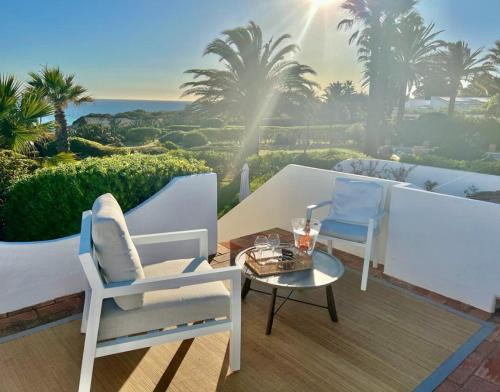 Un patio con dos sillas y una mesa en un balcón. en Casa Eureca, en Carvoeiro