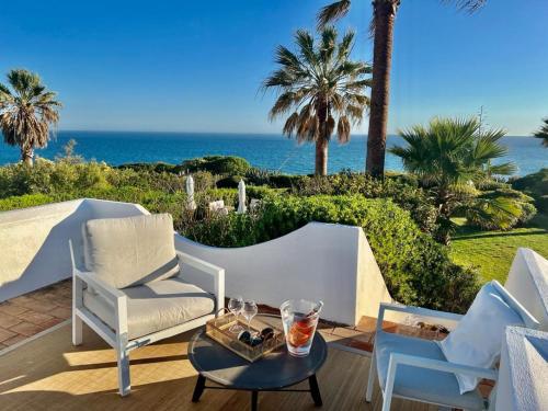 un patio con sillas y una mesa con vistas al océano en Casa Eureca, en Carvoeiro