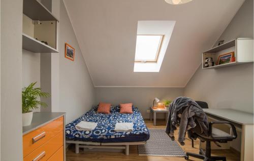 Cette petite chambre mansardée comprend un lit et un bureau. dans l'établissement 2 Bedroom Amazing Home In Warzenko, à Warzenko