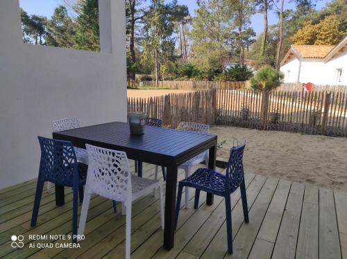 une table noire et des chaises sur une terrasse dans l'établissement Appartement La Savinière, à La Tranche-sur-Mer