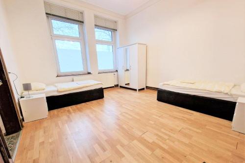 a large room with two beds and a wooden floor at Central located Apartments in Bergisch Gladbach
