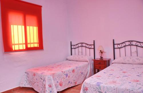 コニル・デ・ラ・フロンテーラにあるCasa El Cortijilloのベッドルーム1室(ベッド2台、窓付)