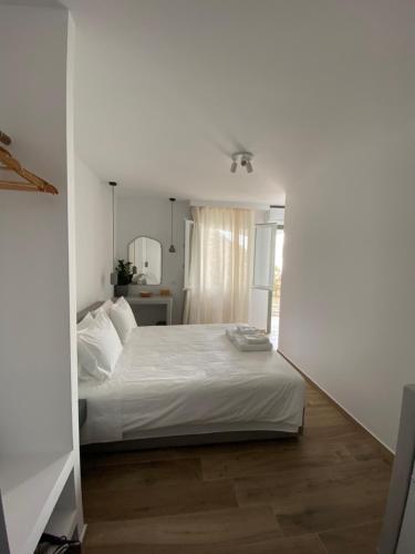 a bedroom with a white bed in a room at THE VIEW OF MYKONOS in Mýkonos City