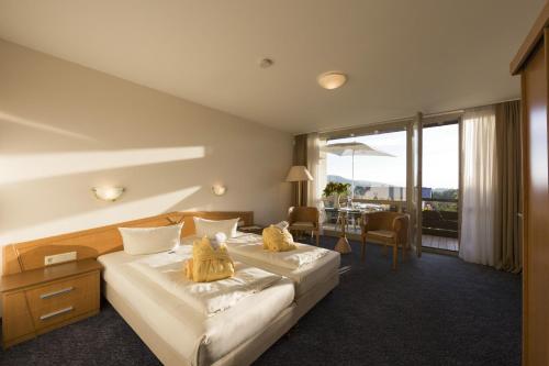 ein Hotelzimmer mit einem großen Bett und einem Tisch in der Unterkunft Sonnenhotel Fürstenbauer in Bodenmais