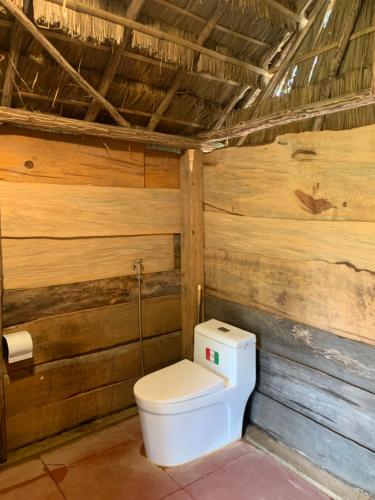 uma casa de banho com WC numa parede de madeira em Hoàng Ánh - Kon Xom Luh em Kon Tum
