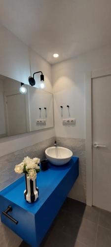 a bathroom with a sink and a blue counter at Alojamiento moderno y sofisticado con vistas a la ciudad in Bilbao