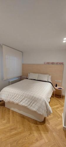 a bedroom with a large bed with a wooden floor at Alojamiento moderno y sofisticado con vistas a la ciudad in Bilbao