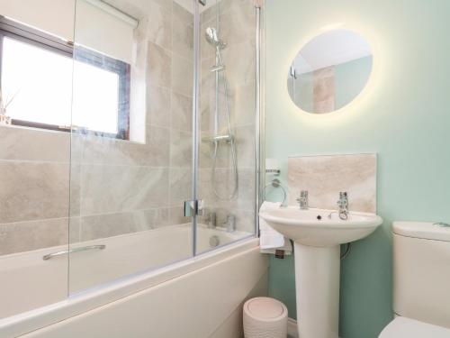 een badkamer met een douche, een wastafel en een bad bij Red Tree Cottage in York
