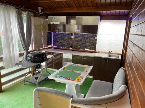 eine Küche mit einem Schreibtisch sowie einem Tisch und Stühlen in der Unterkunft “Home sweet home” in Sîntandrei