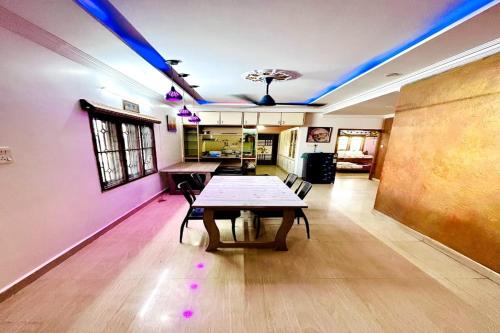 Habitación con mesa y techo con luces moradas. en Jayaram Residency Tirupathi, en Tirupati