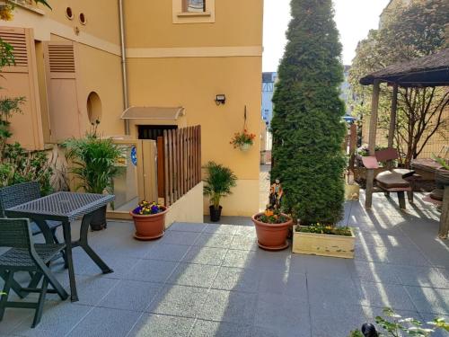 a patio with a table and chairs and plants at Hôtel du Fort in Meulan