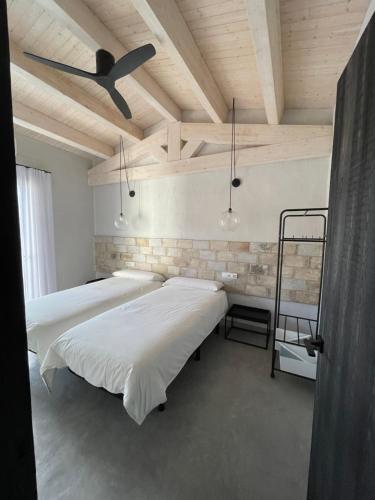 2 łóżka w pokoju z drewnianym sufitem w obiekcie Casa Palma Pals 1 w mieście Pals