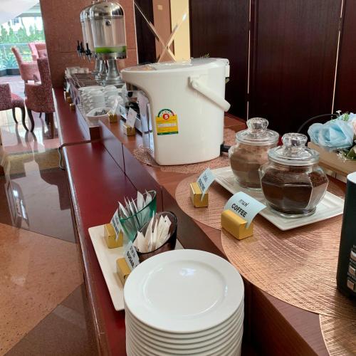 Un mostrador con platos y un procesador de alimentos encima. en Grand Tower Inn Rama 6, en Bangkok