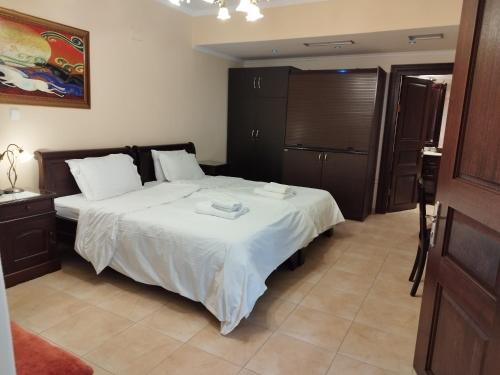 a bedroom with a large bed with white sheets at Pozar Salt Cave Hotel Spa in Kato Loutraki